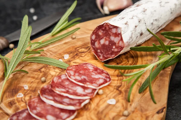 Salami na ciemnym tle — Zdjęcie stockowe