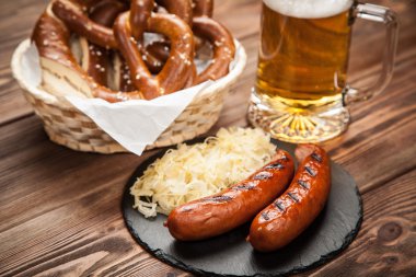 Çubuk kraker, bratwurst ve ahşap masa üzerinde lahana turşusu