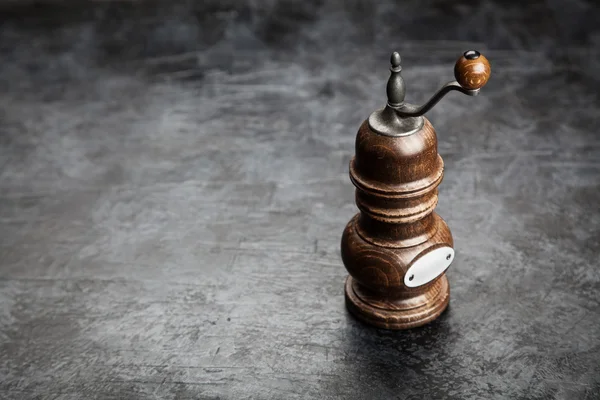 Pfeffermühle auf dunklem Hintergrund — Stockfoto