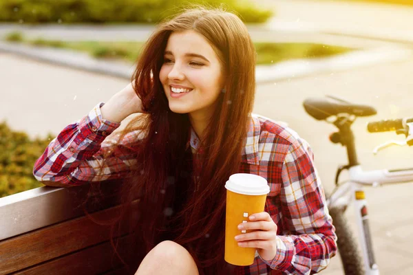 Jonge vrouw drinken koffie op een fietstocht — Stockfoto
