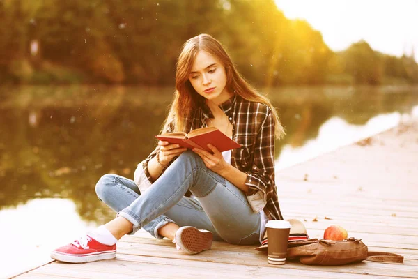 İskelede oturan genç güzel kız