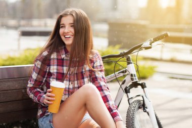 Genç kadın bir bisiklet gezisi kahve içme