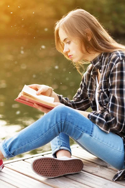 Junges schönes Mädchen sitzt auf einem Pier — Stockfoto