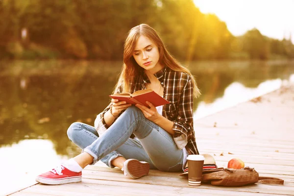 Young beautiful girl sitting on pier — Stock Photo, Image