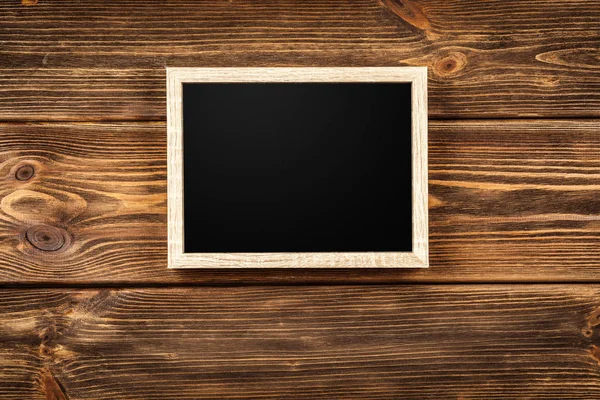 Picture frame on a wooden wall — Stock Photo, Image
