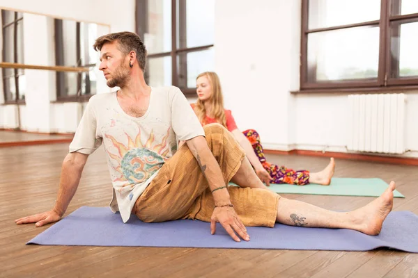 Homem e mulher praticando ioga — Fotografia de Stock