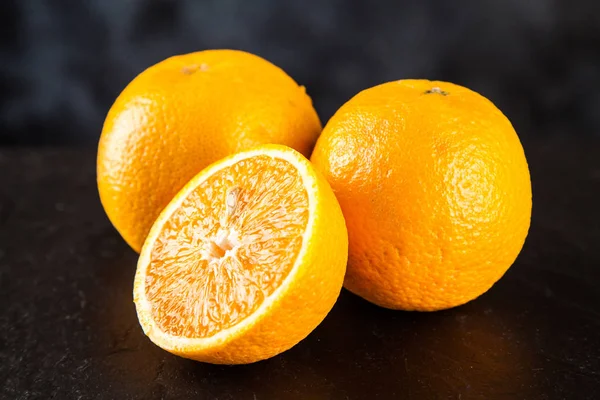 Verse sinaasappels op donkere achtergrond — Stockfoto