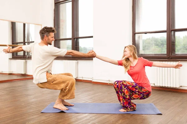 Uomo e donna che praticano yoga partner — Foto Stock