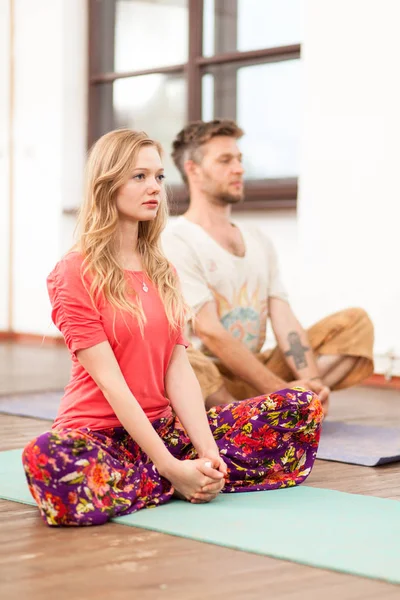 Uomo e donna che praticano yoga — Foto Stock