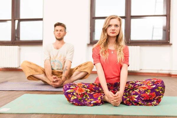 Homem e mulher praticando ioga — Fotografia de Stock