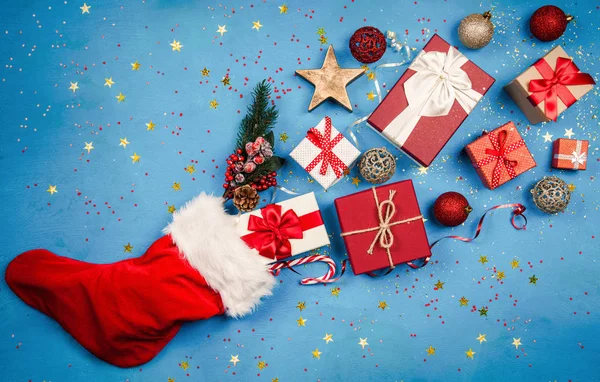 Kerstcadeaus stroomt uit Santas kous — Stockfoto