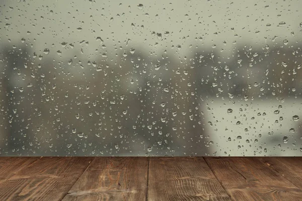 Table on rainy window background — Stock Photo, Image