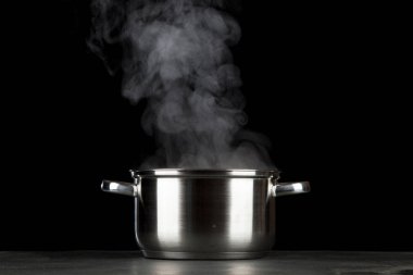 Siyah arka plan üzerinde dumanı tüten pot