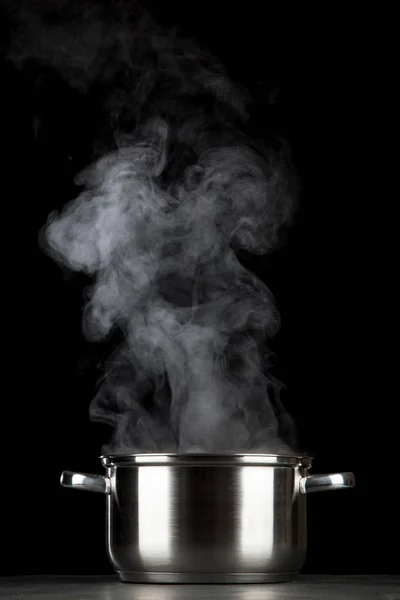 Steaming pot on black background — Stock Photo, Image