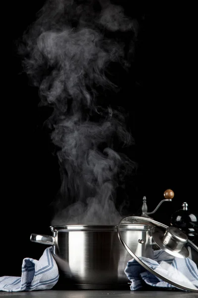 Steaming pot on black background — Stock Photo, Image