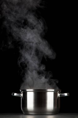 Siyah arka plan üzerinde dumanı tüten pot