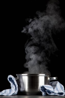 Siyah arka plan üzerinde dumanı tüten pot