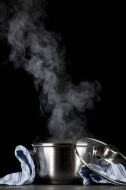 Siyah arka plan üzerinde dumanı tüten pot