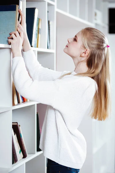 Tiener meisje in een bibliotheek — Stockfoto