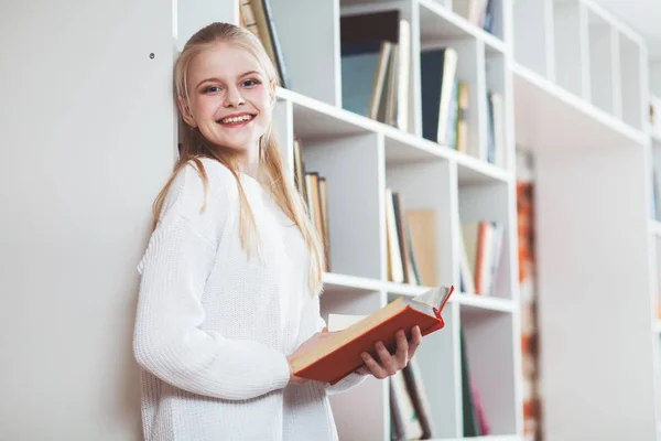 Tonårig flicka i ett bibliotek — Stockfoto