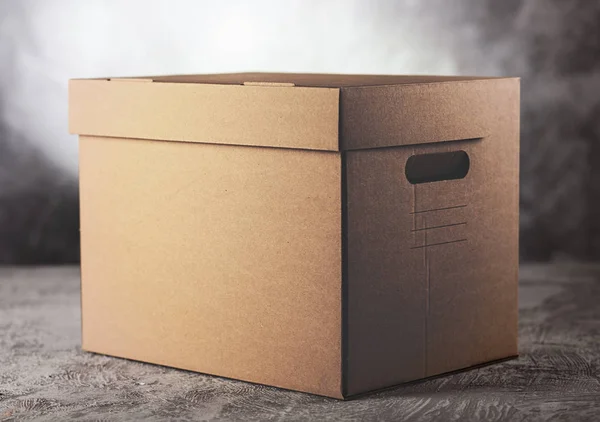 Картонна коробка на сірому фоні — стокове фото