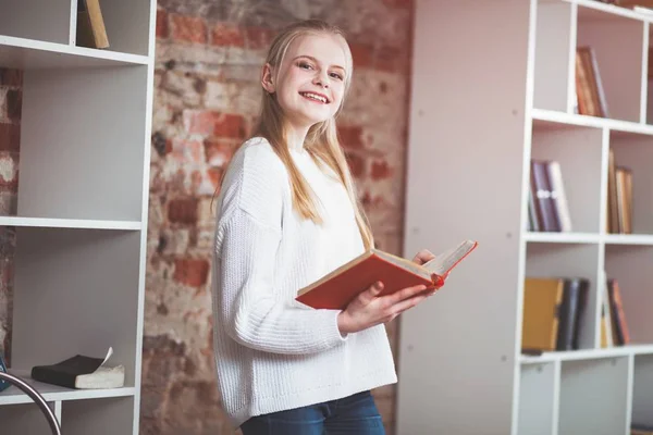 Tonårig flicka i ett bibliotek — Stockfoto