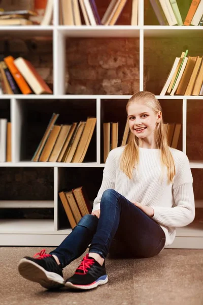 Tiener meisje in een bibliotheek — Stockfoto