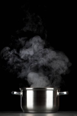 Siyah arka plan üzerinde dumanı tüten pot