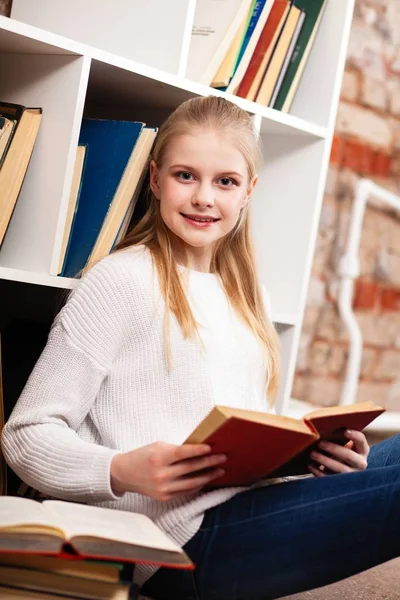 Tiener meisje in een bibliotheek — Stockfoto