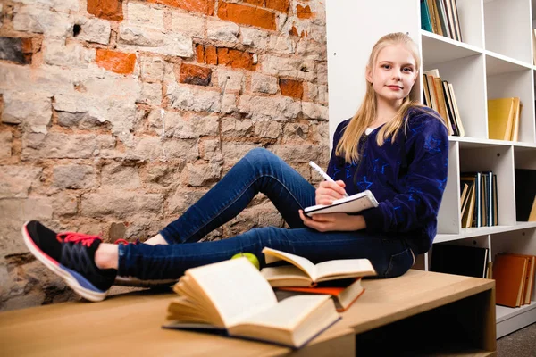 Tiener meisje in een bibliotheek — Stockfoto