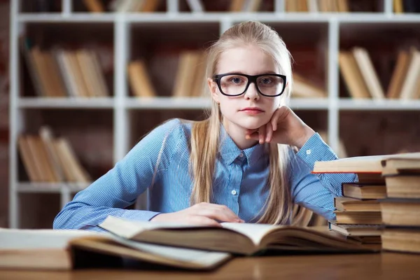 Tonårig flicka i ett bibliotek — Stockfoto