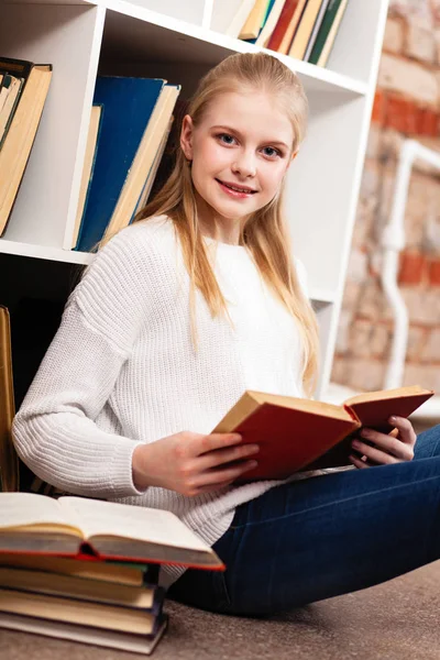 Tiener meisje in een bibliotheek — Stockfoto