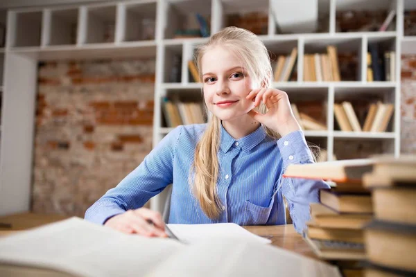 Tonårig flicka i ett bibliotek — Stockfoto