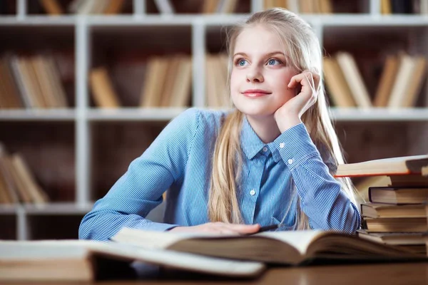 Tonårig flicka i ett bibliotek — Stockfoto