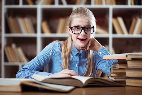 Tizenéves lány egy könyvtárban — Stock Fotó