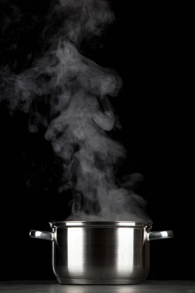 Steaming pot on black background — Stock Photo, Image