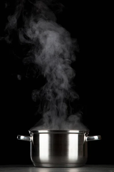 Steaming pot on black background — Stock Photo, Image