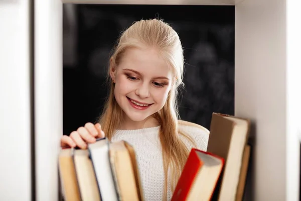 Tiener meisje in een bibliotheek — Stockfoto