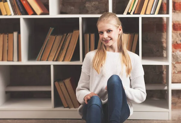 Tonårig flicka i ett bibliotek — Stockfoto