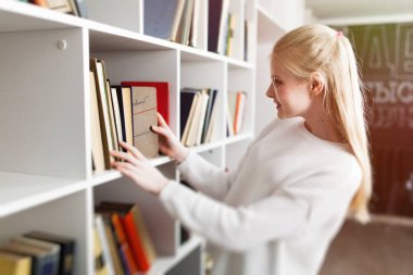 bir kitaplıktaki genç kız