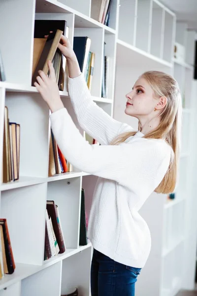 Tiener meisje in een bibliotheek — Stockfoto