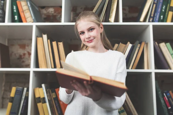 Tonårig flicka i ett bibliotek — Stockfoto