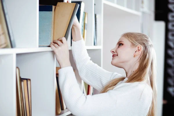 Tonårig flicka i ett bibliotek — Stockfoto