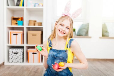Paskalya yumurtaları tutan genç kız