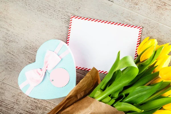 Een brief en gele tulpen op houten achtergrond — Stockfoto