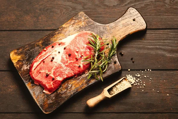 Ahşap kesme tahtası üzerinde çiğ biftek