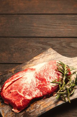 Ahşap kesme tahtası üzerinde çiğ biftek