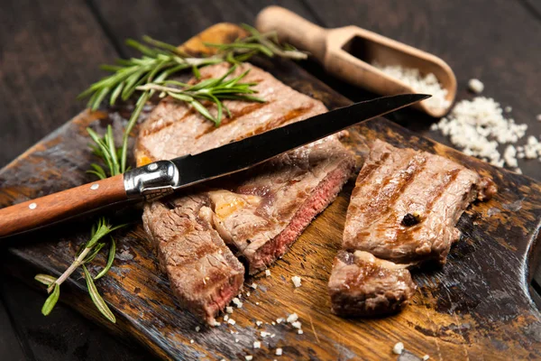 Bife grelhado na placa de corte de madeira — Fotografia de Stock