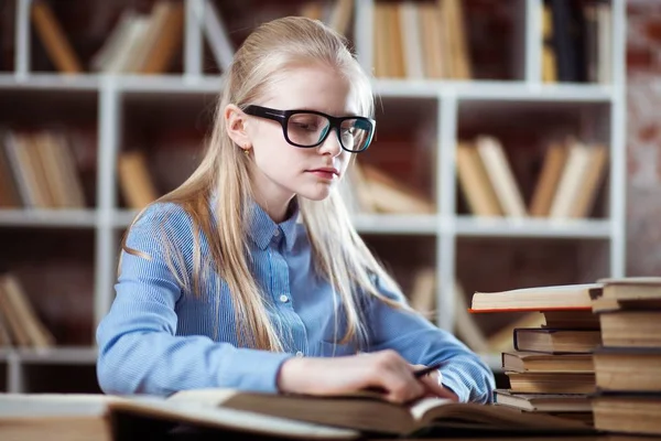 Tonårig flicka i ett bibliotek — Stockfoto