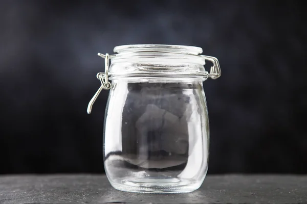 Glass jar on dark background — Stock Photo, Image